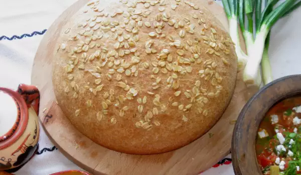 Цельнозерновой хлеб с овсяными хлопьями в керамической кастрюле
