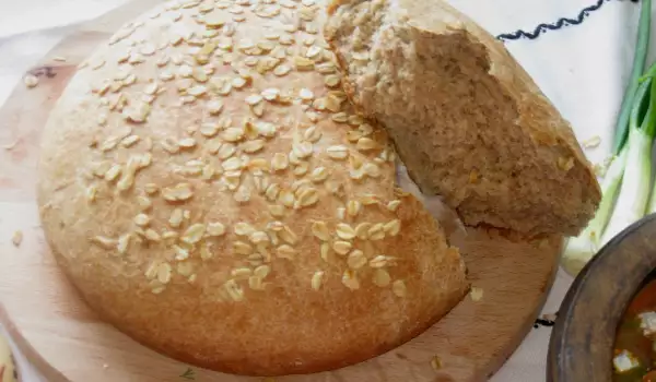 Цельнозерновой хлеб с овсяными хлопьями в керамической кастрюле