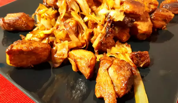 Жареные кусочки свинины с луком-пореем