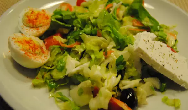 Весенний салат из айсберга, шпината, яиц и оливок