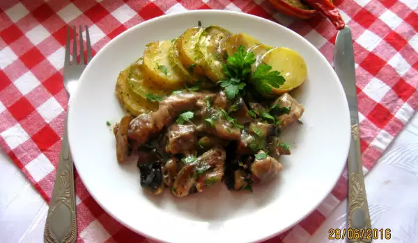 Кусочки свинины с картошкой, кабачками и грибным соусом