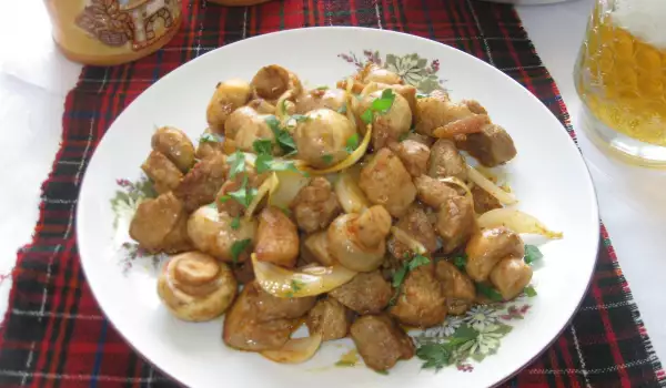 Кусочки свинины с грибами и луком на сковороде