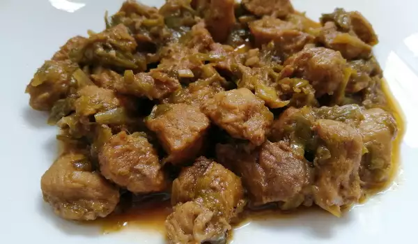 Жареные кусочки свинины с луком-пореем